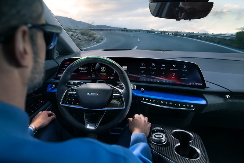 Front View of the 2026 OPTIQ-V Driving Through the Dusk Utilizing its Headlights | Stevens Creek Cadillac in Santa Clara CA